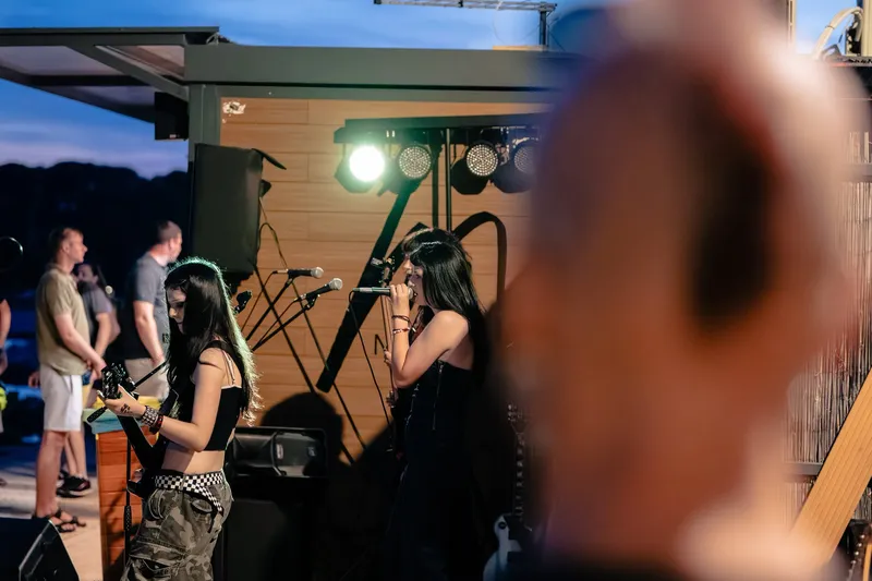Vocalist arms-wide in a strong silhouette