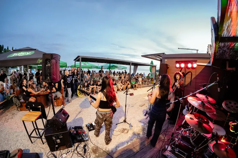 Full band with the sea behind the stage